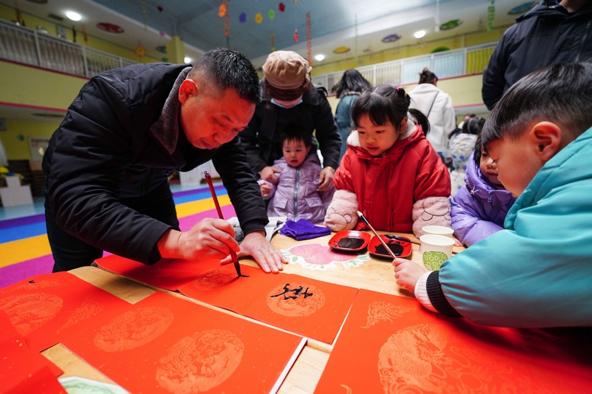 12月30日，在貴州省丹寨縣第三幼兒園，小朋友和家長在參加寫對聯活動。