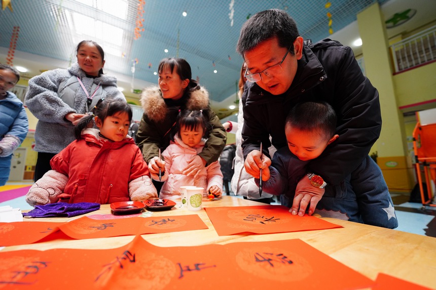 12月30日，在貴州省丹寨縣第三幼兒園，小朋友和家長在參加寫對聯活動。