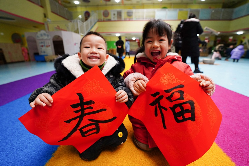 12月30日，在貴州省丹寨縣第三幼兒園，小朋友在展示和家長共同寫的“春”字和“福”字。