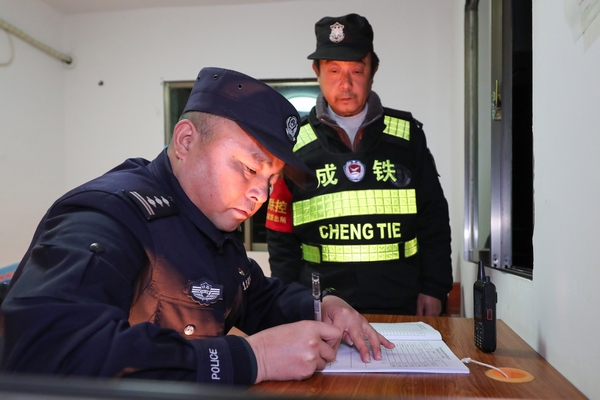2022年1月7日，歐衛東（左）在滬昆高鐵貴州省玉屏侗族自治縣境內巡查線路時填寫巡查記錄。
