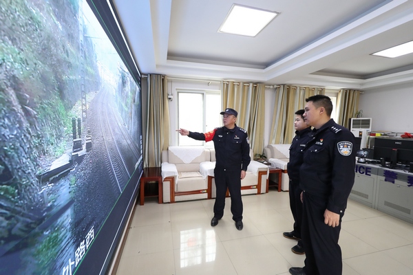 2022年1月9日，欧卫东（左一）在沪昆高铁贵州铜仁南站与民警分析监控区域安全。