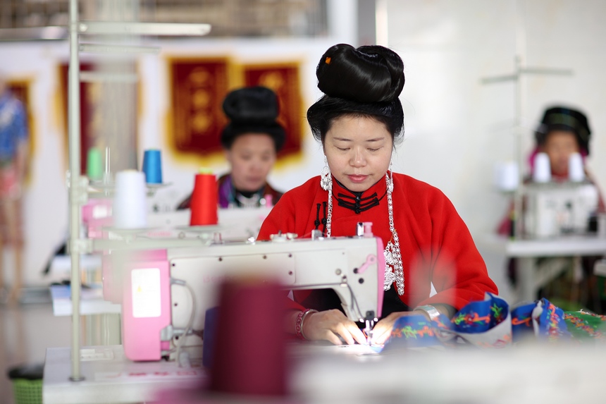 1月11日，搬迁群众在贵州省丹寨县金泉街道易地扶贫搬迁安置点民族服饰手工坊缝制传统苗族服装。