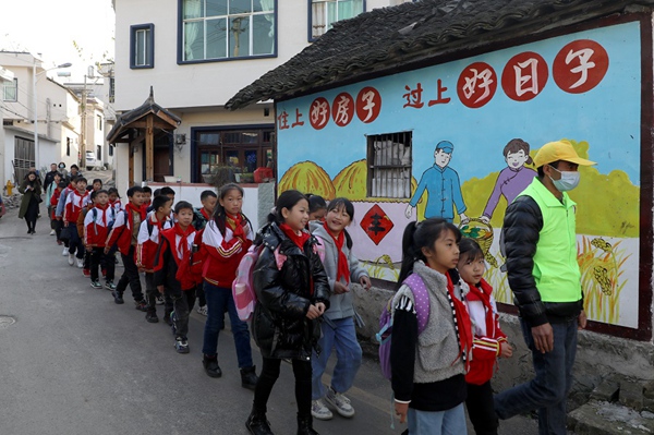 放学后，随车安全志愿者陪伴学生安全上校车。观山湖区融媒体中心供图