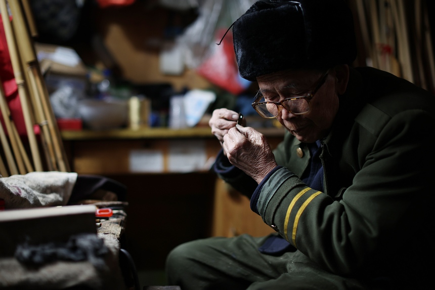 1月13日，在貴州省丹寨縣興仁鎮興仁村一家蘆笙制作工坊，工匠在調試簧片的音色。黃曉海攝