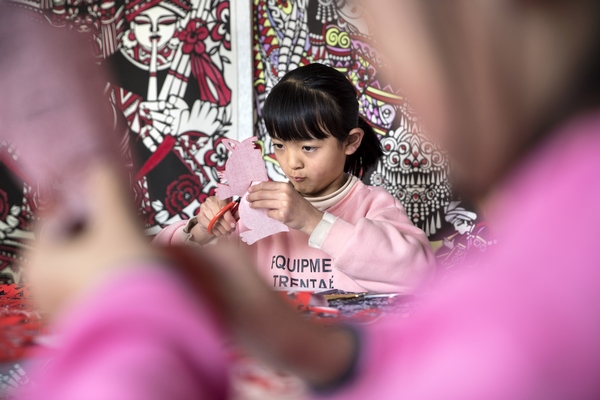 2022年1月18日，貴州省黔西市剪紙非遺傳承人岳紅霞在自己的工作室裡上公益課，學生進行“剪虎迎新春”創作。