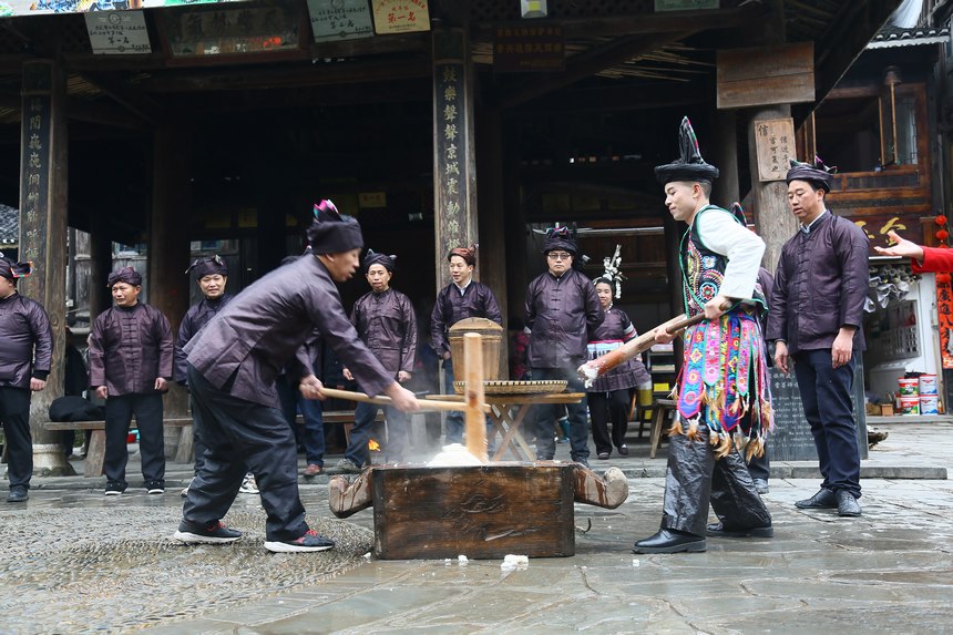 “村晚”主持人一起参与到群众打糍粑活动中，体验侗族新年。