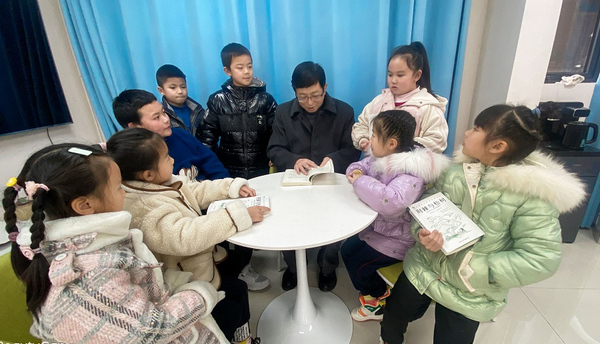 小朋友們圍在老師身邊聽寓言故事。