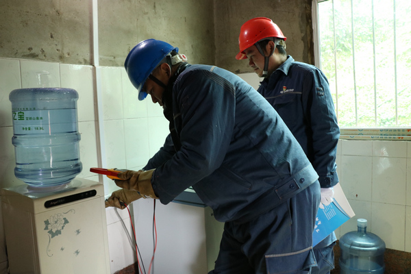 南方電網貴州銅仁玉屏供電局新店供電所正在群眾家中正在測量線路。