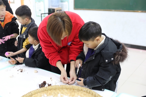 志愿者在教孩子们包汤圆。