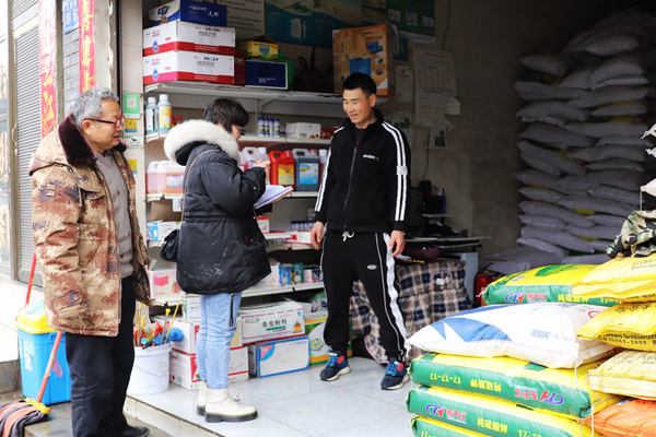 卫城镇农业服务中心工作人员在检查农资店。