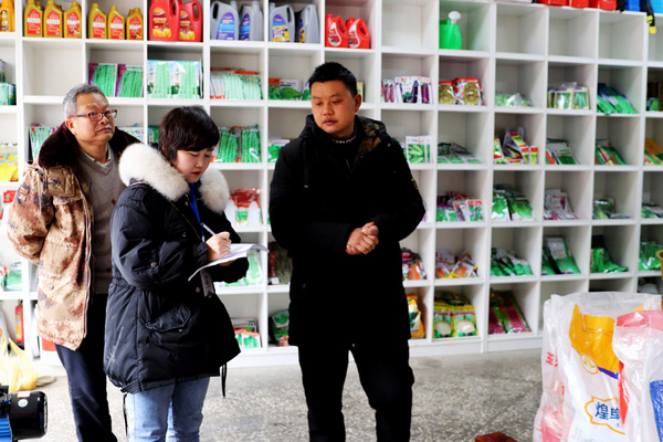 卫城镇农业服务中心工作人员在检查农资店。