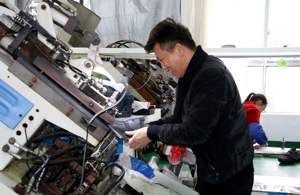 2022年2月17日，贵州毕节亿卓鞋厂员工在放楦头。