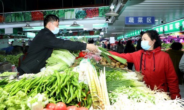 驍博農貿市場內市民購買食材。