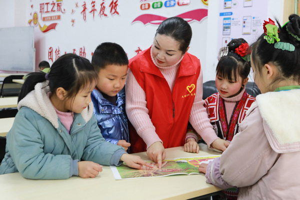 2月22日，在剑河县思源社区的新时代智慧农家书屋里，志愿者正在指导小朋友阅读。刘梦摄
