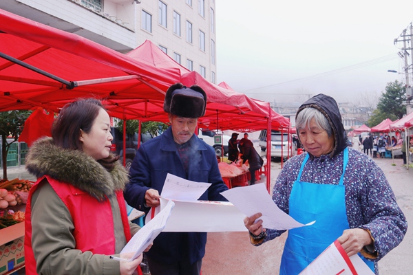 开阳县高寨乡集镇依托赶集日向过往群众发放治风倡议书。