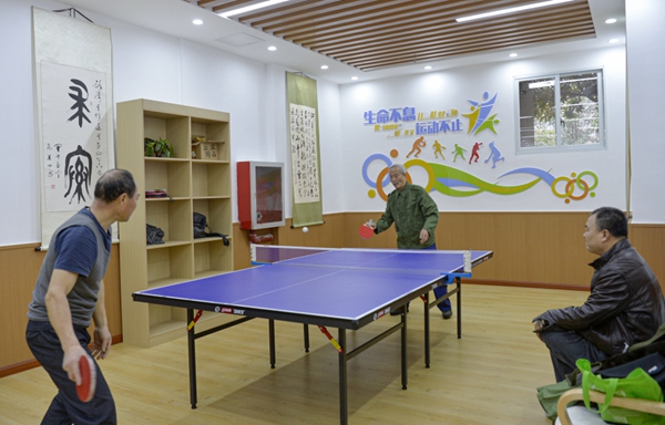王玉學與同伴在金元社區養老服務站打乒乓球。