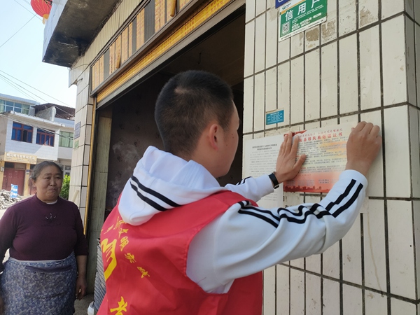 堰塘村志愿者张贴移风易俗倡议书。宅吉乡供图