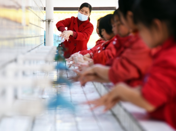小朋友们在老师的指导下学习正确的洗手方法。 熊军万摄