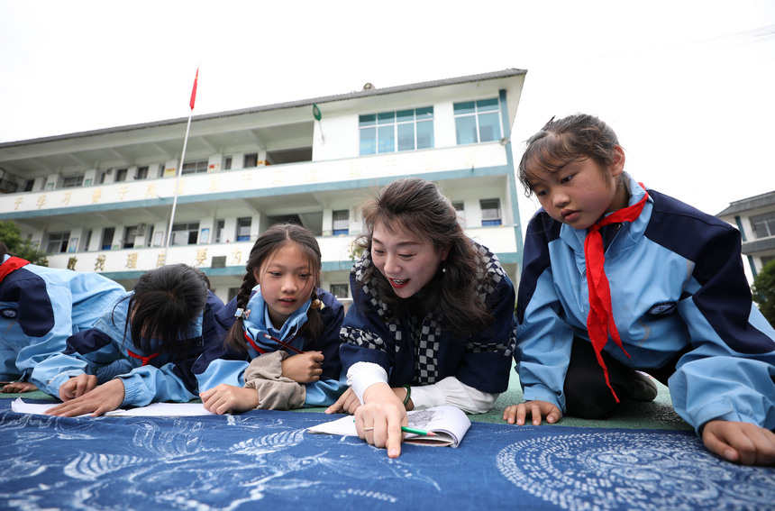 5月17日，外聘老師在貴州省丹寨縣龍泉鎮羊甲小學課后服務中指導學生描繪苗族傳統蠟染圖案。