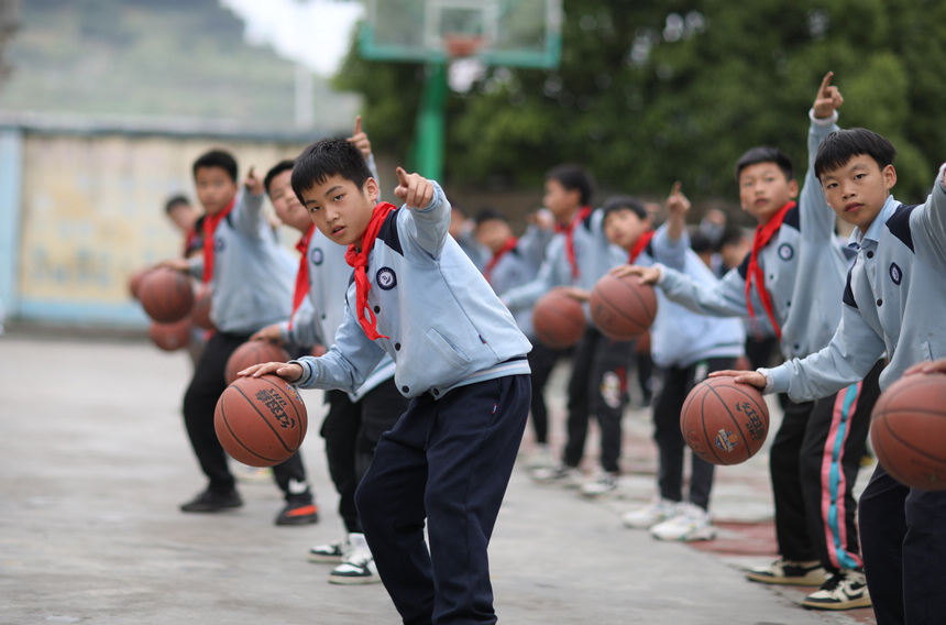 5月17日，小學生在貴州省丹寨縣龍泉鎮羊甲小學課后服務中練習籃球基本動作。