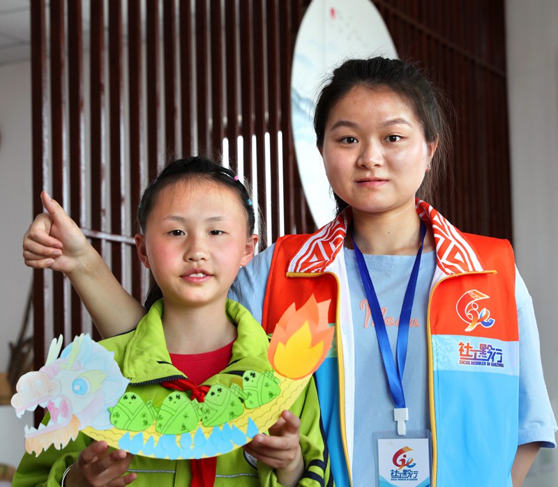 2022年6月2日，贵州省黔西市锦绣花都易地扶贫搬迁安置点，搬迁群众的孩子展示自己手工制作的龙舟。