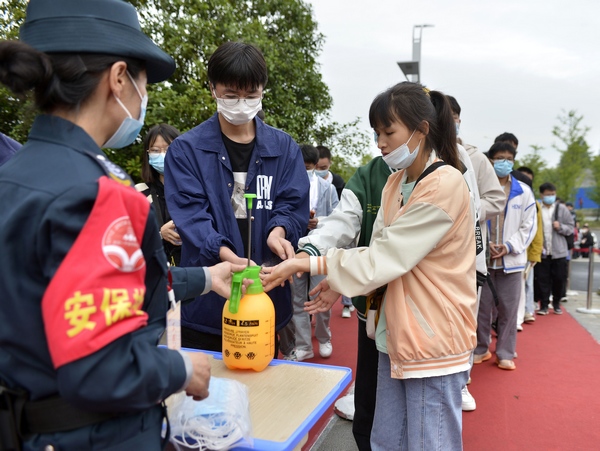 6月7日，考生在貴州省大方縣金塔英才學校考點進行消毒進入考點。周訓貴攝