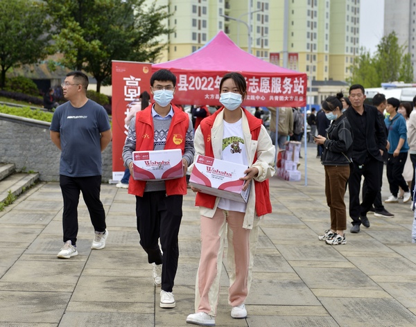 6月7日，在貴州省大方縣金塔英才學校考點自願者在為考生提供水等服務。周訓貴攝