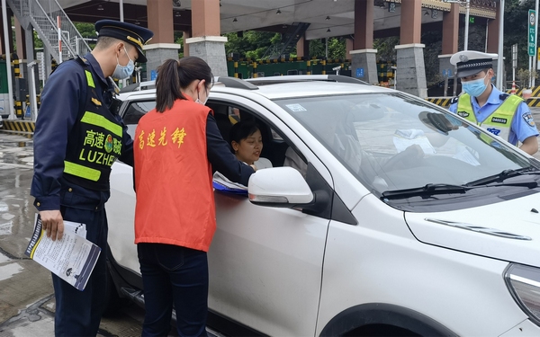 高速路政執法人員對過往車輛進行宣傳。楊明貴攝