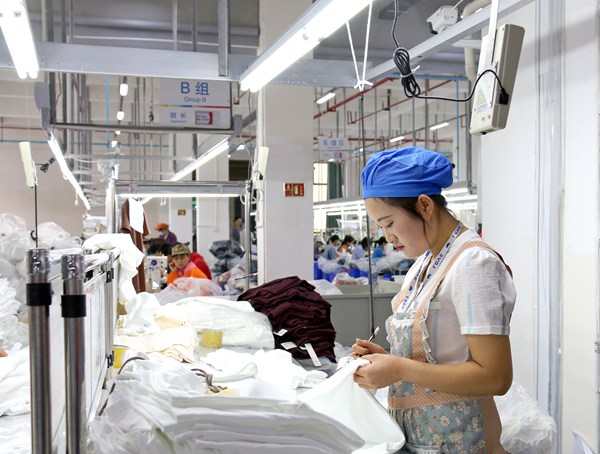晶煌制衣有毕节市限公司生产车间，工人在品检。