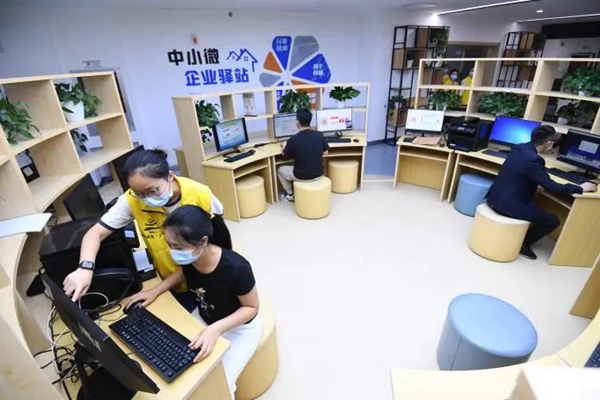 南明区政务服务大厅“小南政务专员”在中小微企业驿站指导企业办事人员自主申报业务。