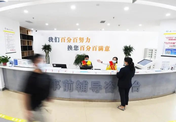 南明区政务服务大厅事前帮办咨询人员在引导企业办事人员到窗口区域办理业务。
