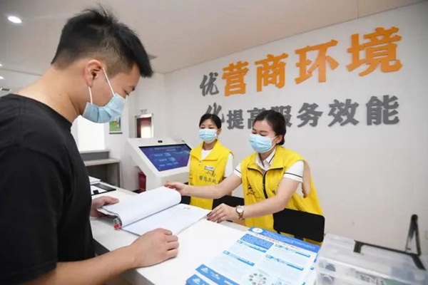 企业办事人员在南明区政务服务大厅法人服务区事前辅导咨询台进行业务咨询。
