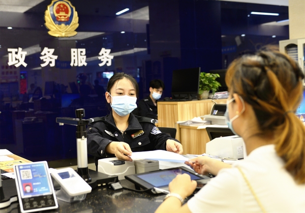 大方縣政務服務大廳民警把資料遞交給辦事群眾。