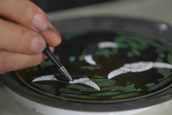 贵州省毕节市大方县高光漆器厂高光友在给漆器进行装饰。