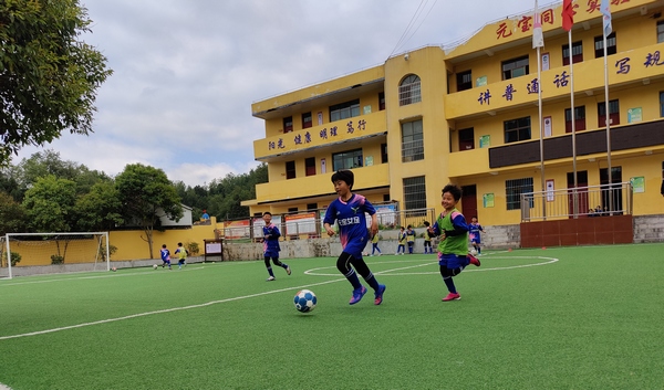 元寶小學足球隊在建好的足球場上踢球。