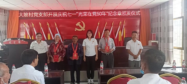 大坡村向老党员授予“光荣在党50年”纪念章。