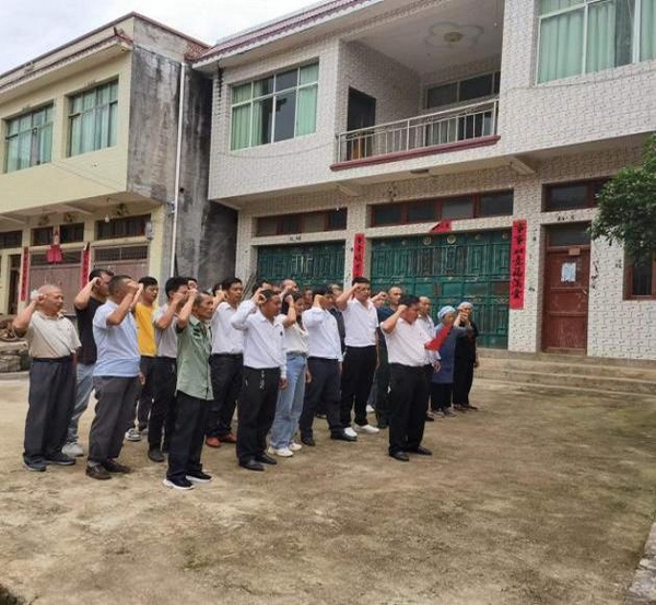 新山村全体党员在戈厂组红军标语文化点重温入党誓词。