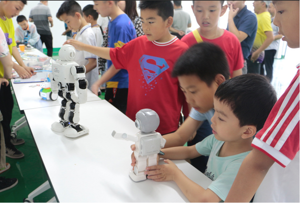 同学们参观体验机器人。