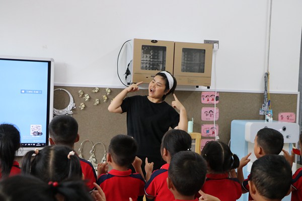 皂角坪中心幼兒園的老師和幼兒一起表演防溺水手勢舞。