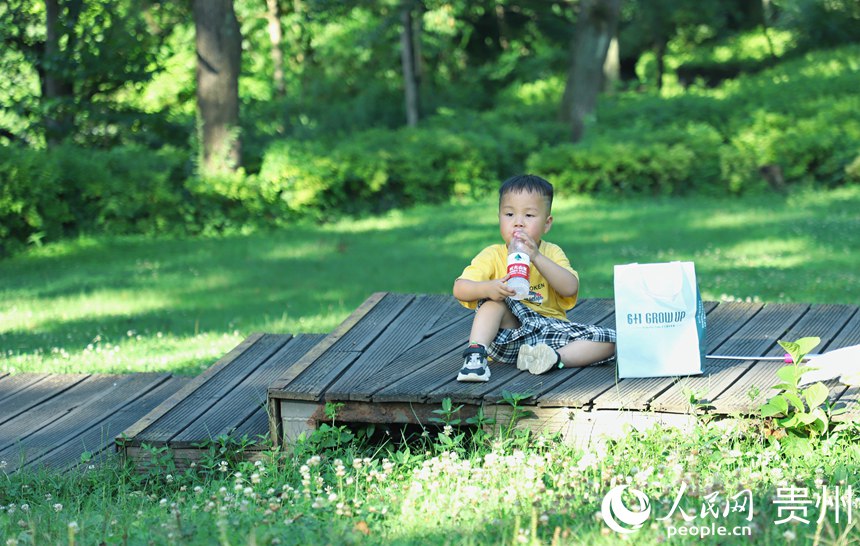 在阿哈湖公园内小男孩在喝水。人民网 顾兰云摄