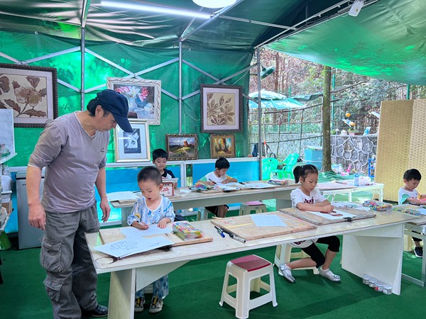 成建正指导孩子们画画。彭光杰摄
