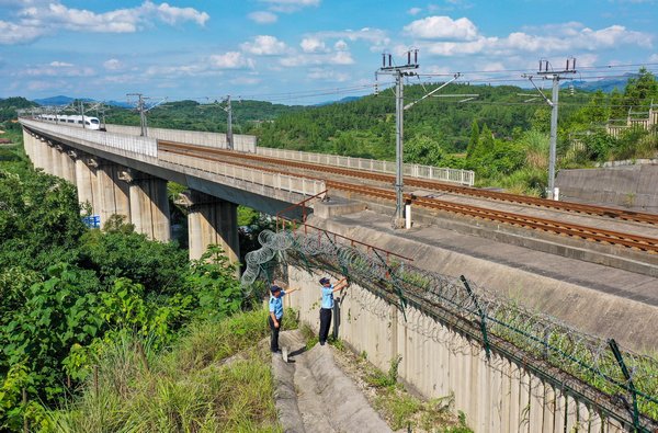 2022年7月13日，铁路公安民警在沪昆高铁贵州省铜仁市玉屏侗族自治县境内对防护网进行检查。