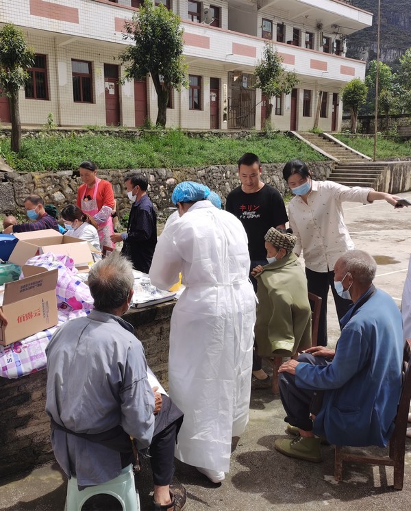 县医院组织人员到沙坎村为六十岁以上老人接种疫苗。