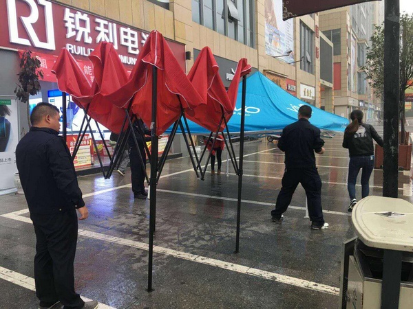 开阳县执法人员对城区的撑杆搭蓬进行整治。