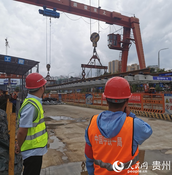 7月20日，工作人员正在指挥轨道吊装。人民网 王钦摄