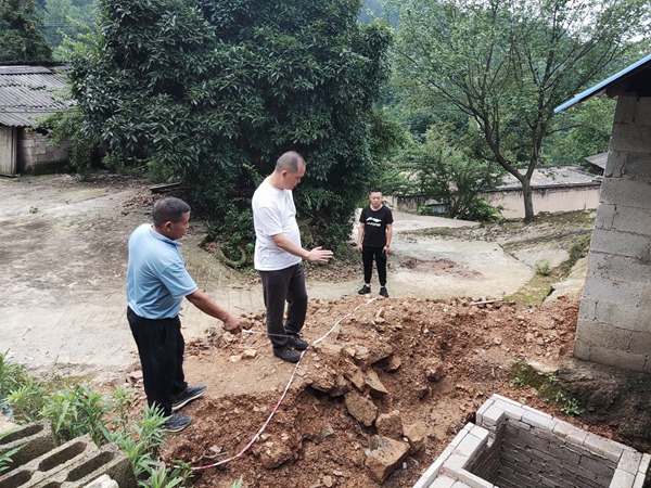 圖為：工作人員到轄區大壩村實地查看農村生活污水處理池建設情況