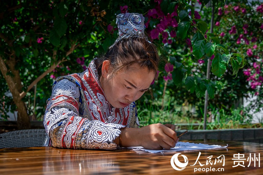 化屋村異地扶貧搬遷點內，苗族同胞正在制作苗族傳統蠟染。人民網 涂敏攝