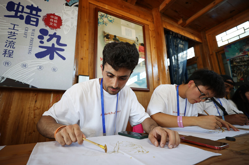 7月21日，留學生在學習苗族蠟染繪畫。