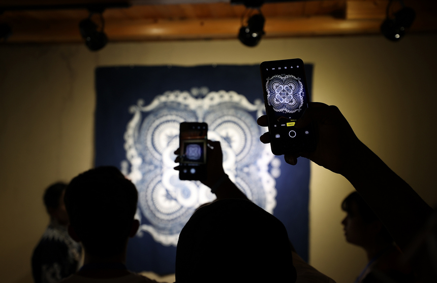 7月21日，留學生用手機拍攝苗族蠟染傳統圖案。