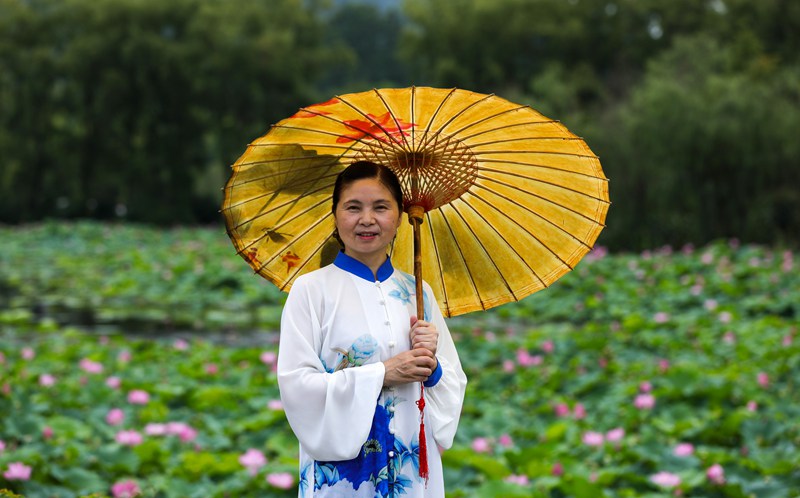 7月23日,游客在龙潭古寨观赏荷花。